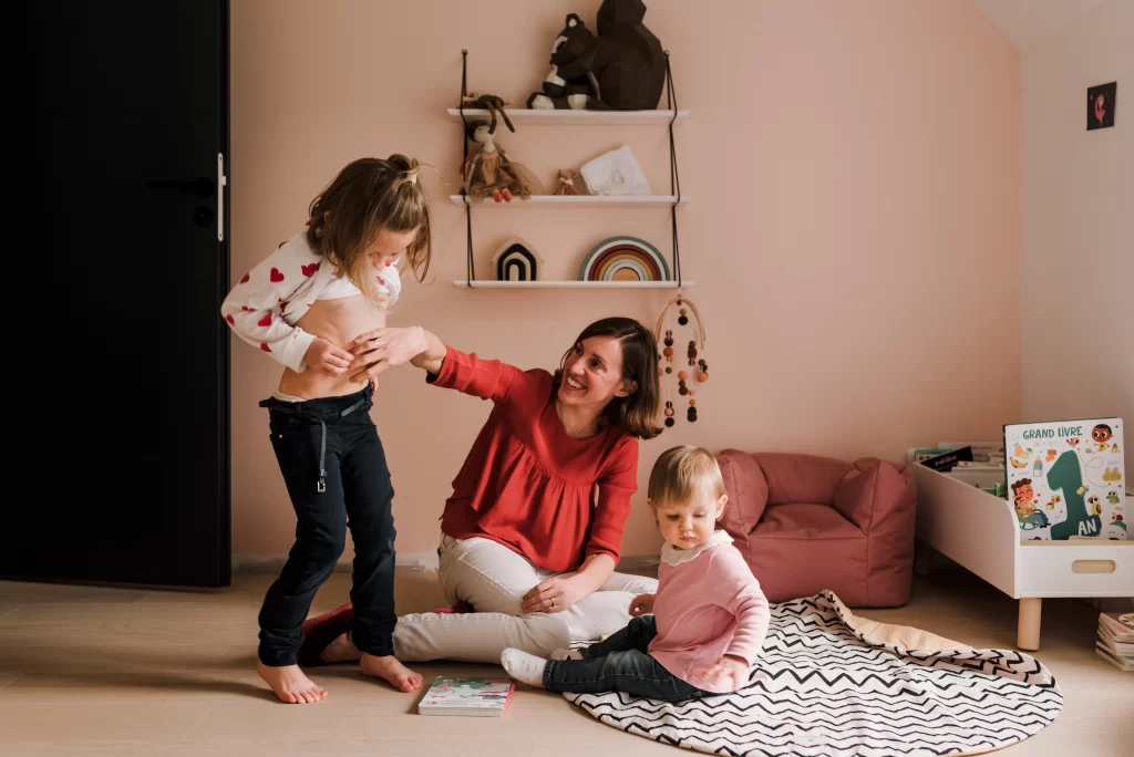 une maman riant avec ses filles pendant une séance photo famille avec stéphanie daillet photographe
