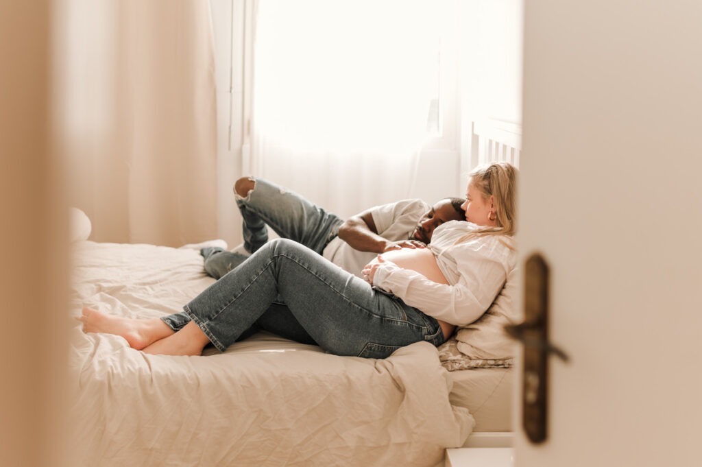 Séance grossesse à domicile, futurs parents enlacés